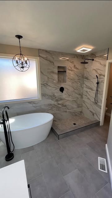 Bathroom with freestanding tub, tiled shower and black fixtures